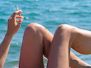 woman relaxes by the sea smoking  cigarette