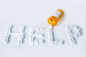 "Help" spelled out with pills